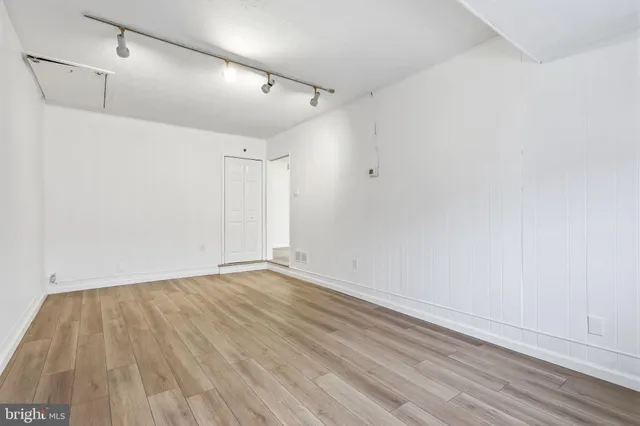 a view of an empty room with wooden floor