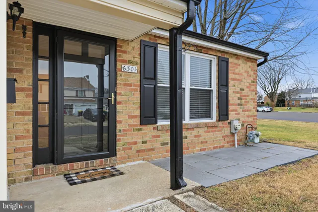 a view of a brick house with a large tree