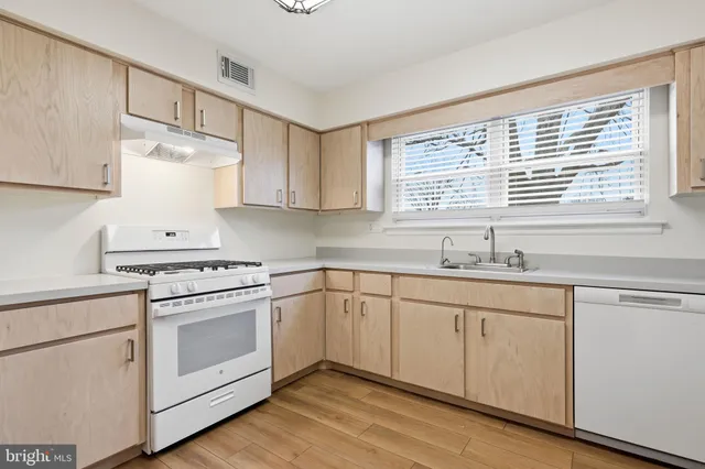 a kitchen with granite countertop white cabinets and white appliances
