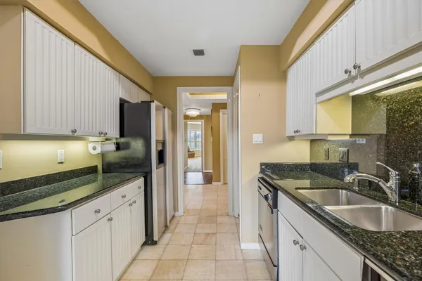a kitchen with granite countertop a sink and cabinets