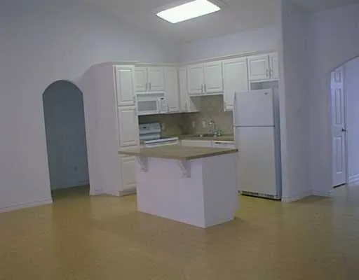 a kitchen with stainless steel appliances granite countertop a refrigerator a sink and a stove