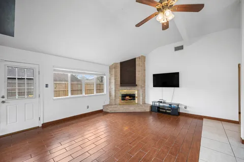 a view of a livingroom with a flat screen tv wooden floor and a ceiling fan