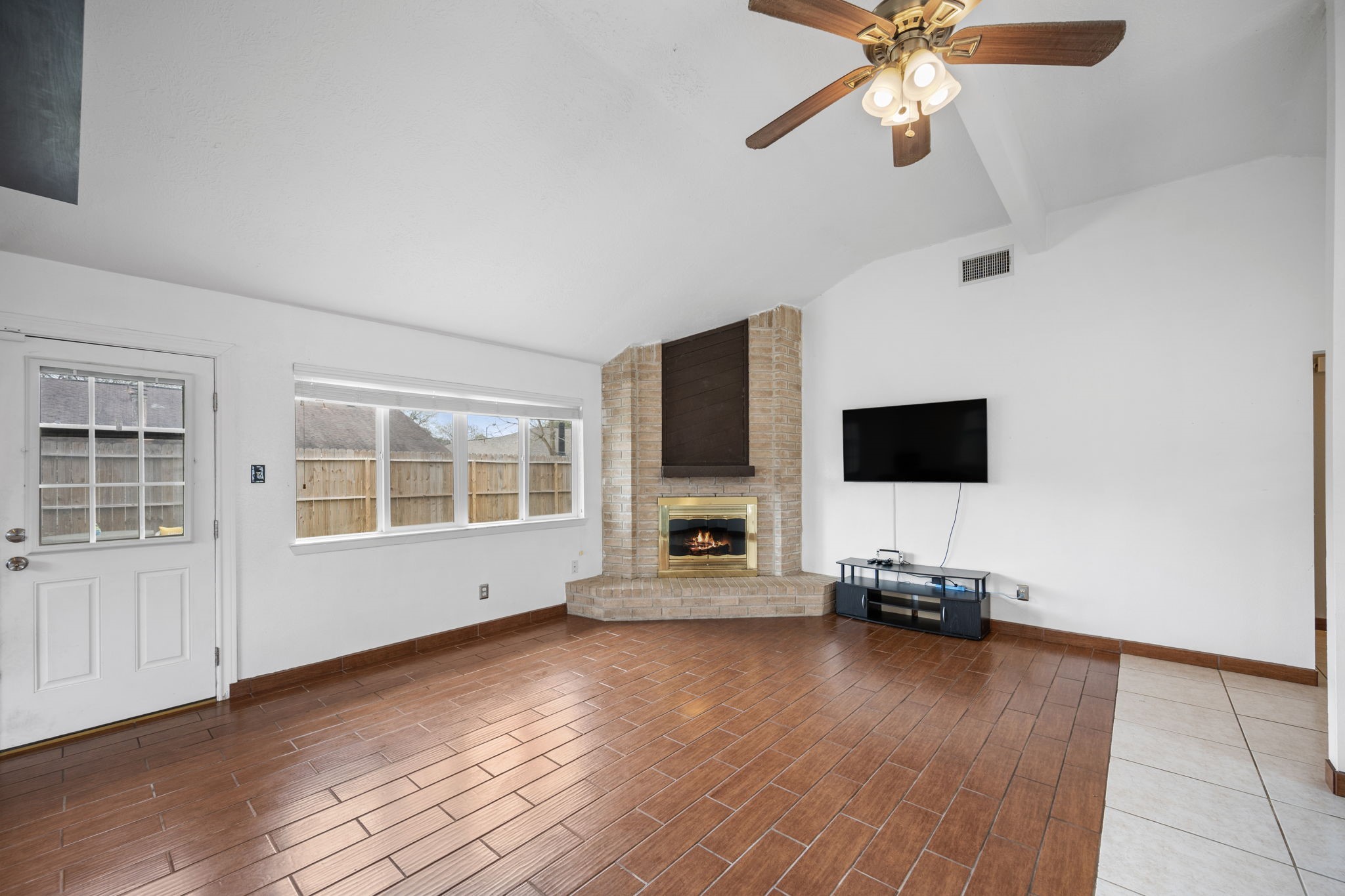 2327 Colonial Ridge Drive Friendswood, TX 77546 - Photo 11 of 27 a view of a livingroom with a flat screen tv wooden floor and a ceiling fan