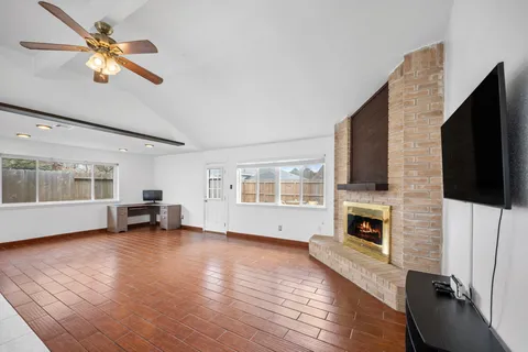 a view of empty room with fireplace and wooden floor