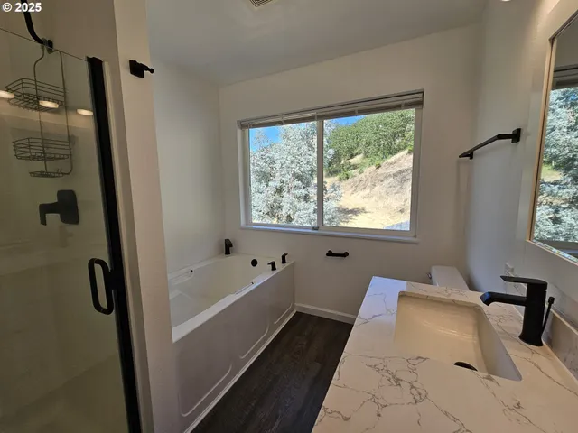 a bathroom with a tub a window and a shower
