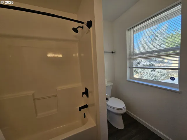 a bathroom with a toilet and a shower