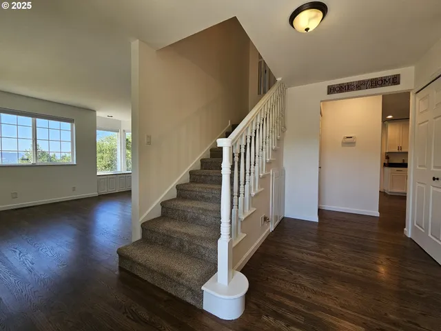 a view of entryway and hall with wooden floor