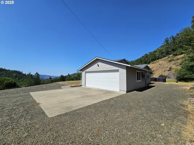 a view of a house with a yard and large tree