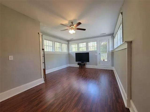 a view of a livingroom with wooden floor and a ceiling fan
