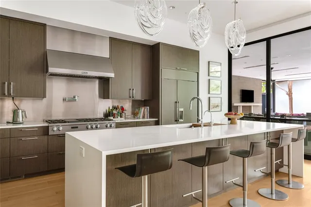 a large kitchen with stainless steel appliances granite countertop a lot of counter space and a large window