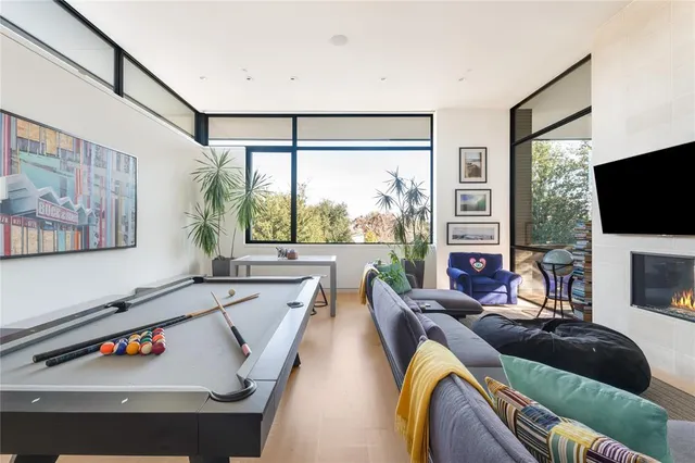 a living room with furniture a flat screen tv and a large window