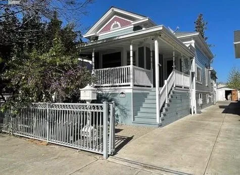 a view of a house with wooden fence and two windows