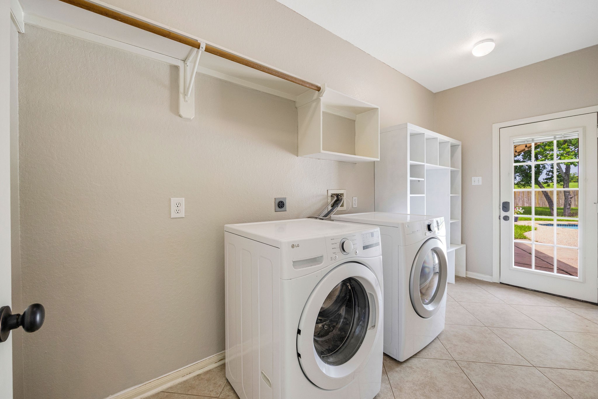 9603 Randon Lane Missouri City, TX 77459 - Photo 25 of 50 The utility room/mud room features storage shelves and plenty of room for another refrigerator. This entry to the backyard flows under a breezeway to the 3-car garage. Washer and dryer convey with the home.
