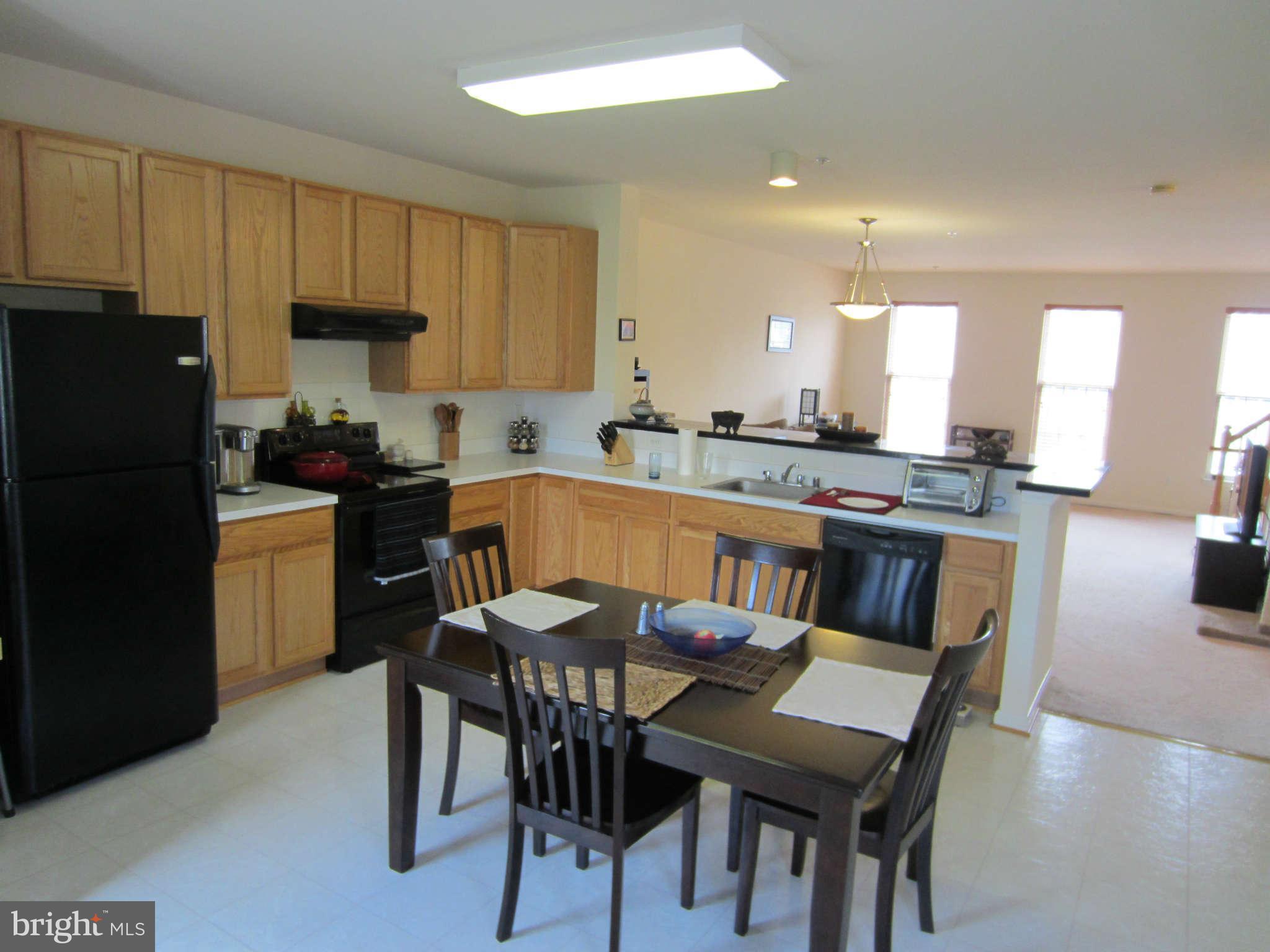 512 Ellison Court Frederick, MD 21703 - Photo 14 of 30 a kitchen with stainless steel appliances granite countertop a stove a refrigerator a sink a dining table and chairs