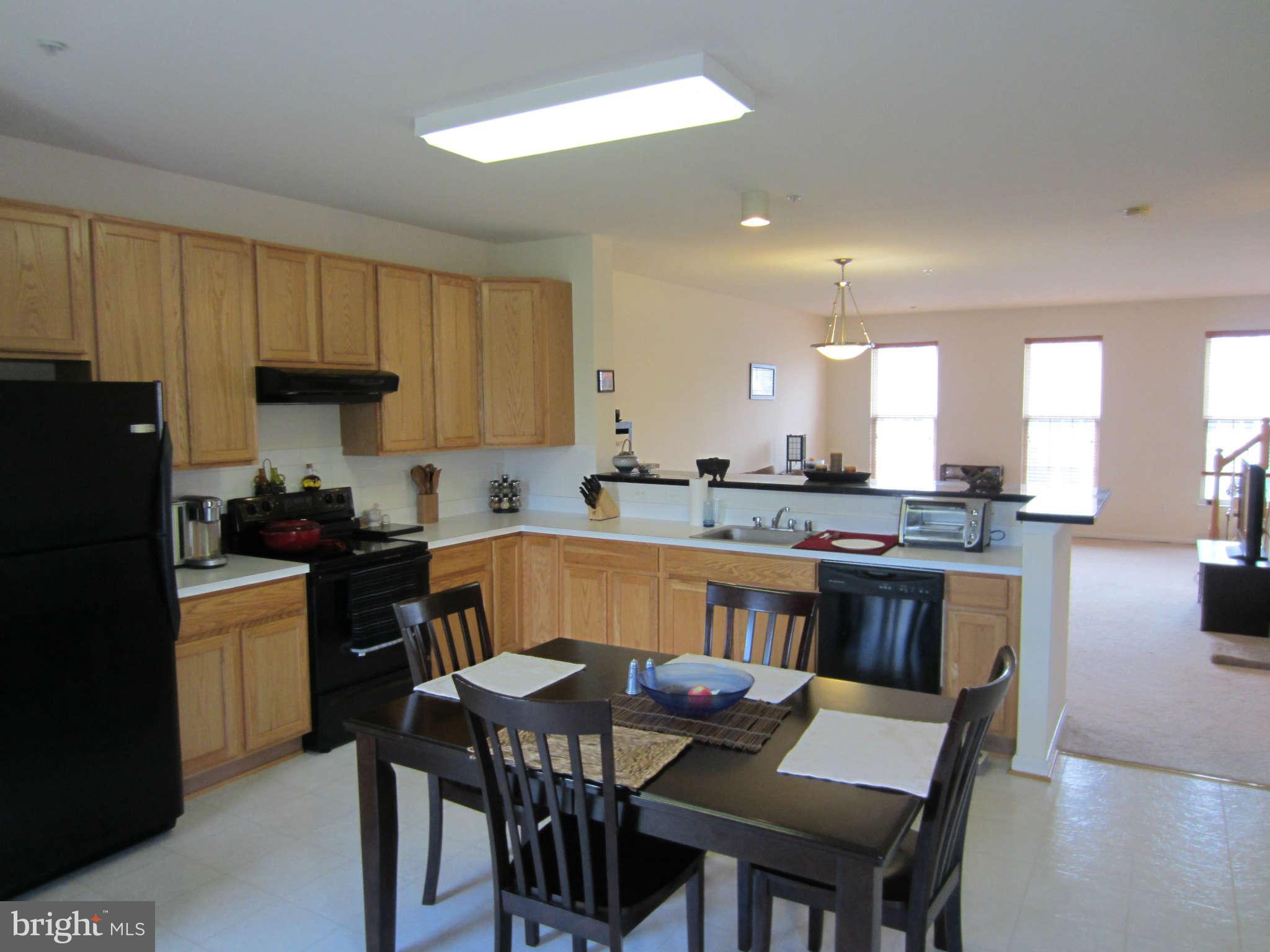 512 Ellison Court Frederick, MD 21703 - Photo 16 of 30 a kitchen with a dining table chairs and refrigerator