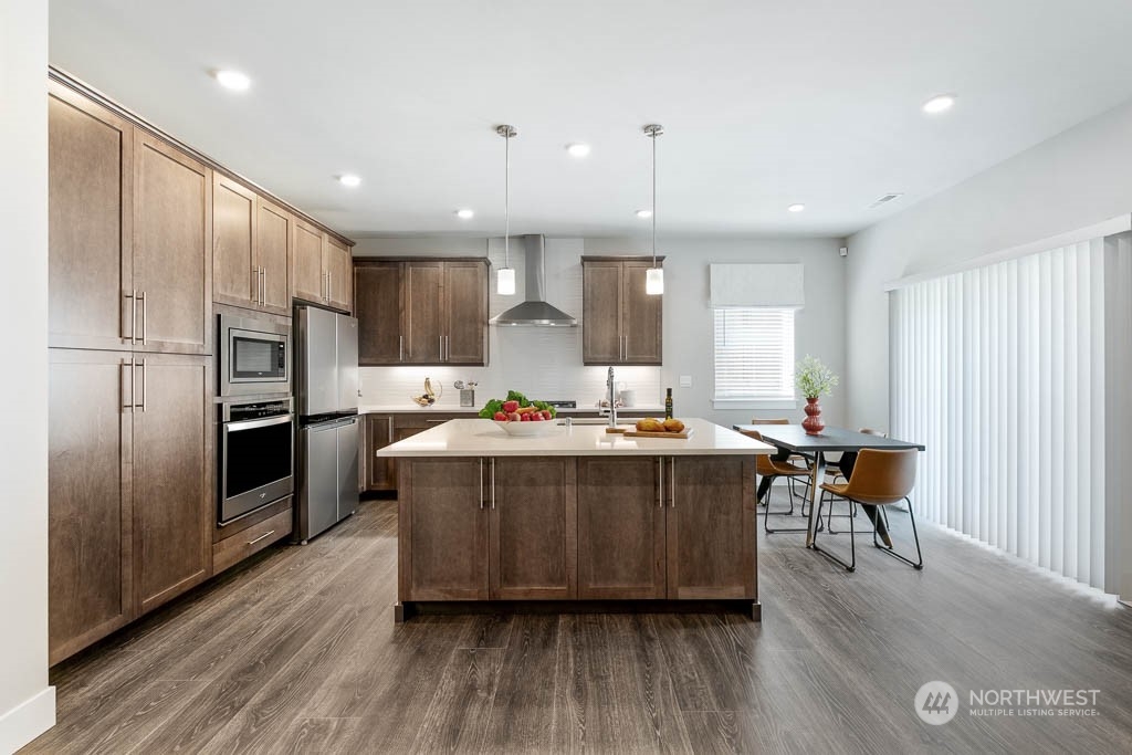 22917 20th Place West Bothell, WA 98021 - Photo 13 of 32 a large kitchen with stainless steel appliances wooden floors and wooden cabinets
