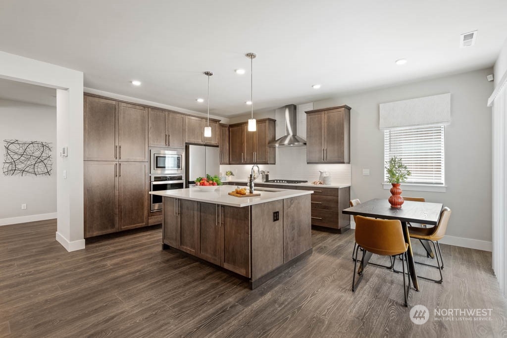 22917 20th Place West Bothell, WA 98021 - Photo 2 of 32 a kitchen with stainless steel appliances granite countertop a refrigerator a sink dishwasher a stove and a microwave oven with wooden floor