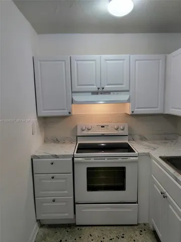 a stove top oven sitting inside of a kitchen