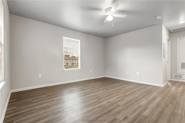 wooden floor in an empty room with a window