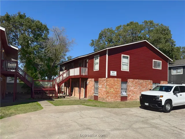 a view of a car parked in front of a brick house