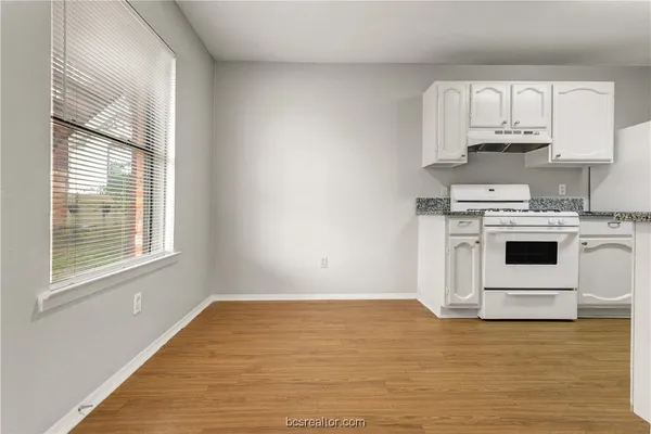 a view of a kitchen with wooden floor and electronic appliances