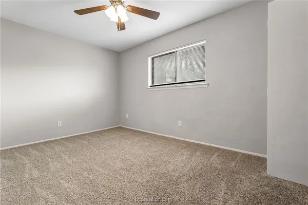 an empty room with a chandelier fan