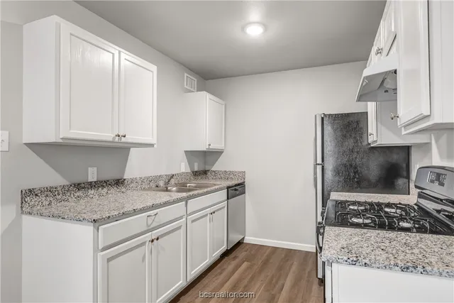 a kitchen with a sink stove and cabinets