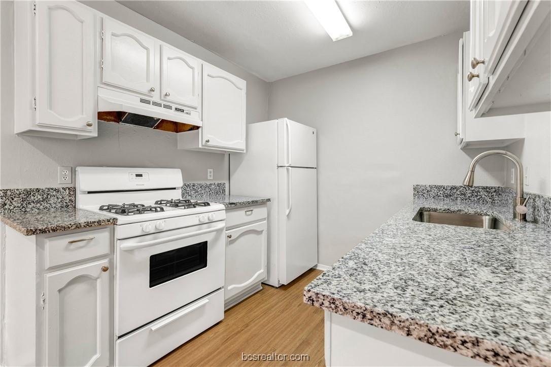802-804 Navidad Street Bryan, TX 77801 - Photo 45 of 48 a kitchen with granite countertop white cabinets and white appliances