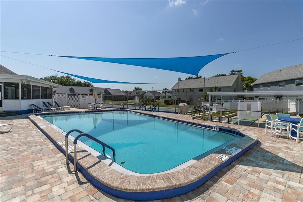 6129 Elmhurst Drive New Port Richey, FL 34653 - Photo 3 of 34 a view of a swimming pool with outdoor seating