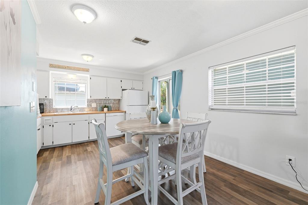 6129 Elmhurst Drive New Port Richey, FL 34653 - Photo 5 of 34 a kitchen with a dining table chairs wooden floor and appliances