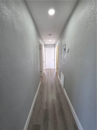 a view of a hallway with wooden floor