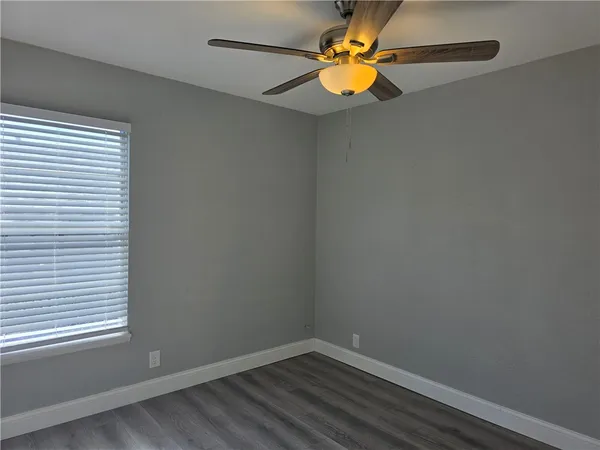 a view of a small space with wooden floor and a window