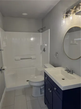 a bathroom with a sink a toilet and shower