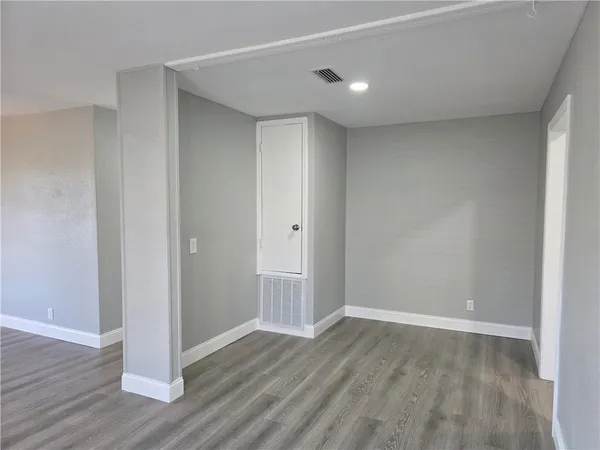 a view of an empty room with wooden floor