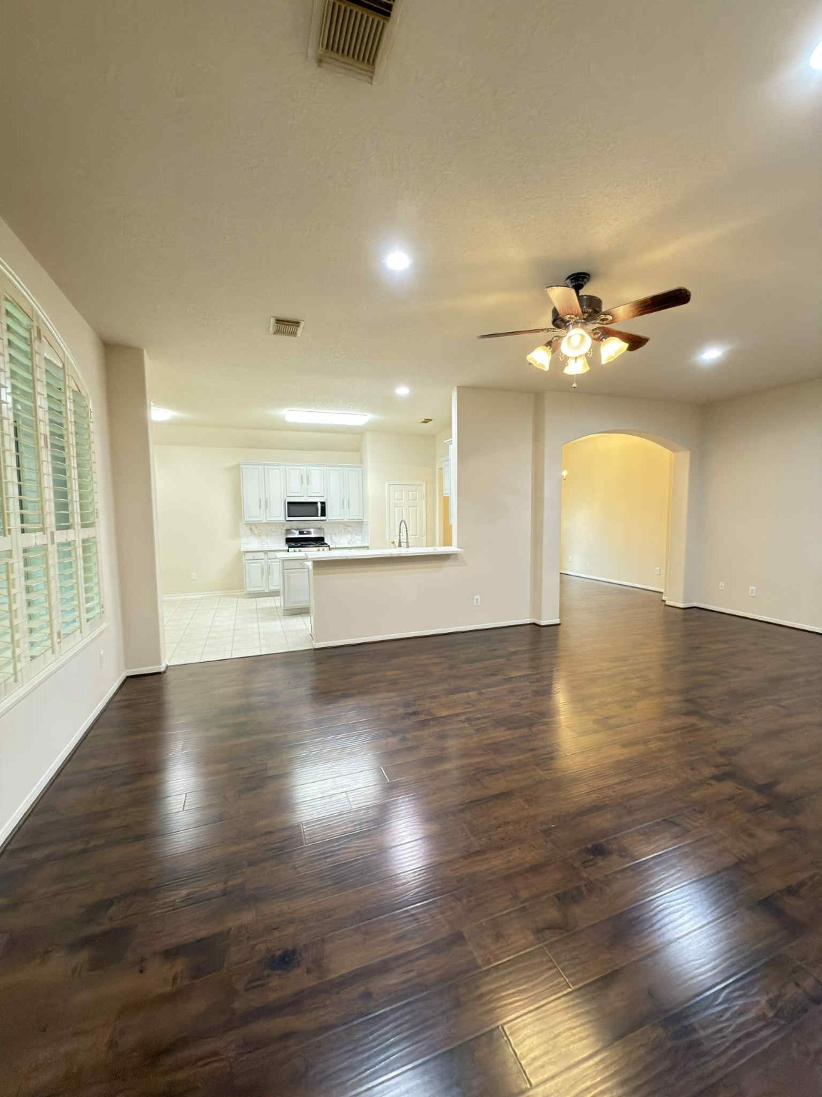 9531 Summer Run Houston, TX 77064 - Photo 8 of 29 an empty room with wooden floor a ceiling fan and kitchen view