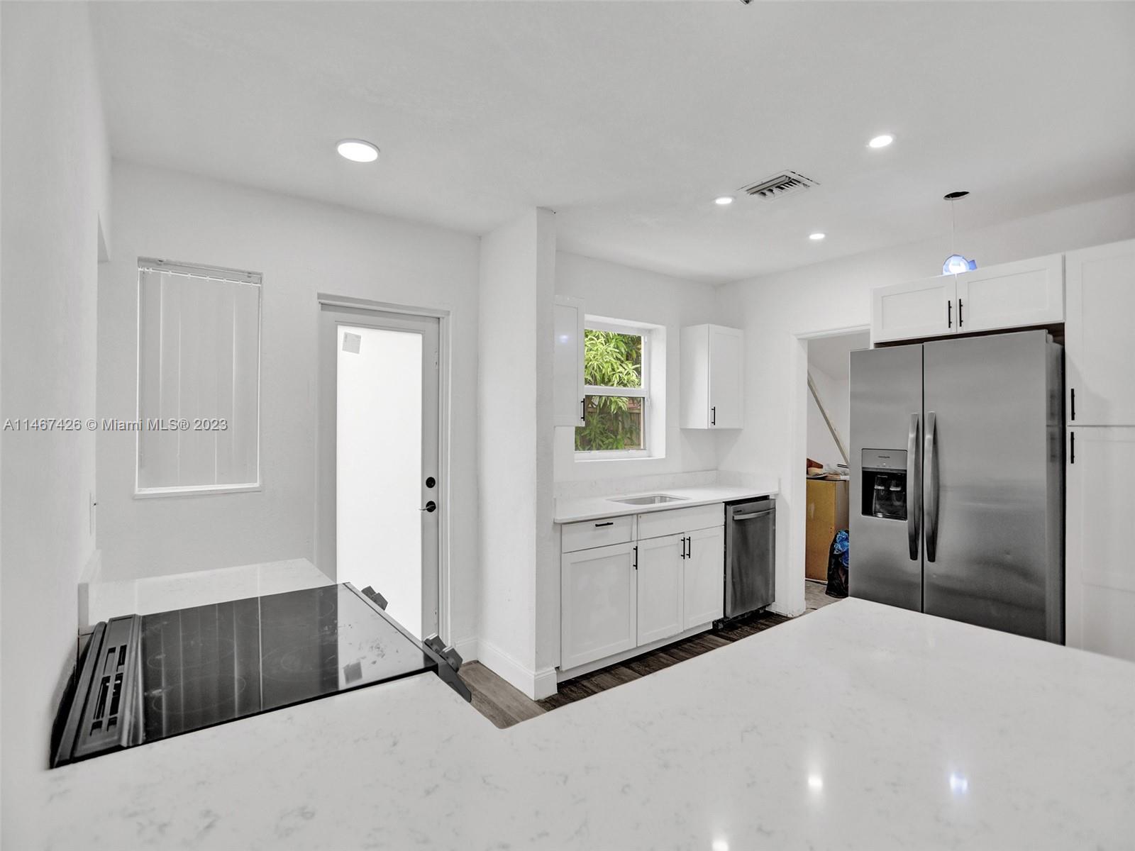 167 Northwest 84th Street Miami, FL 33150 - Photo 12 of 39 a kitchen with stainless steel appliances a refrigerator and a sink