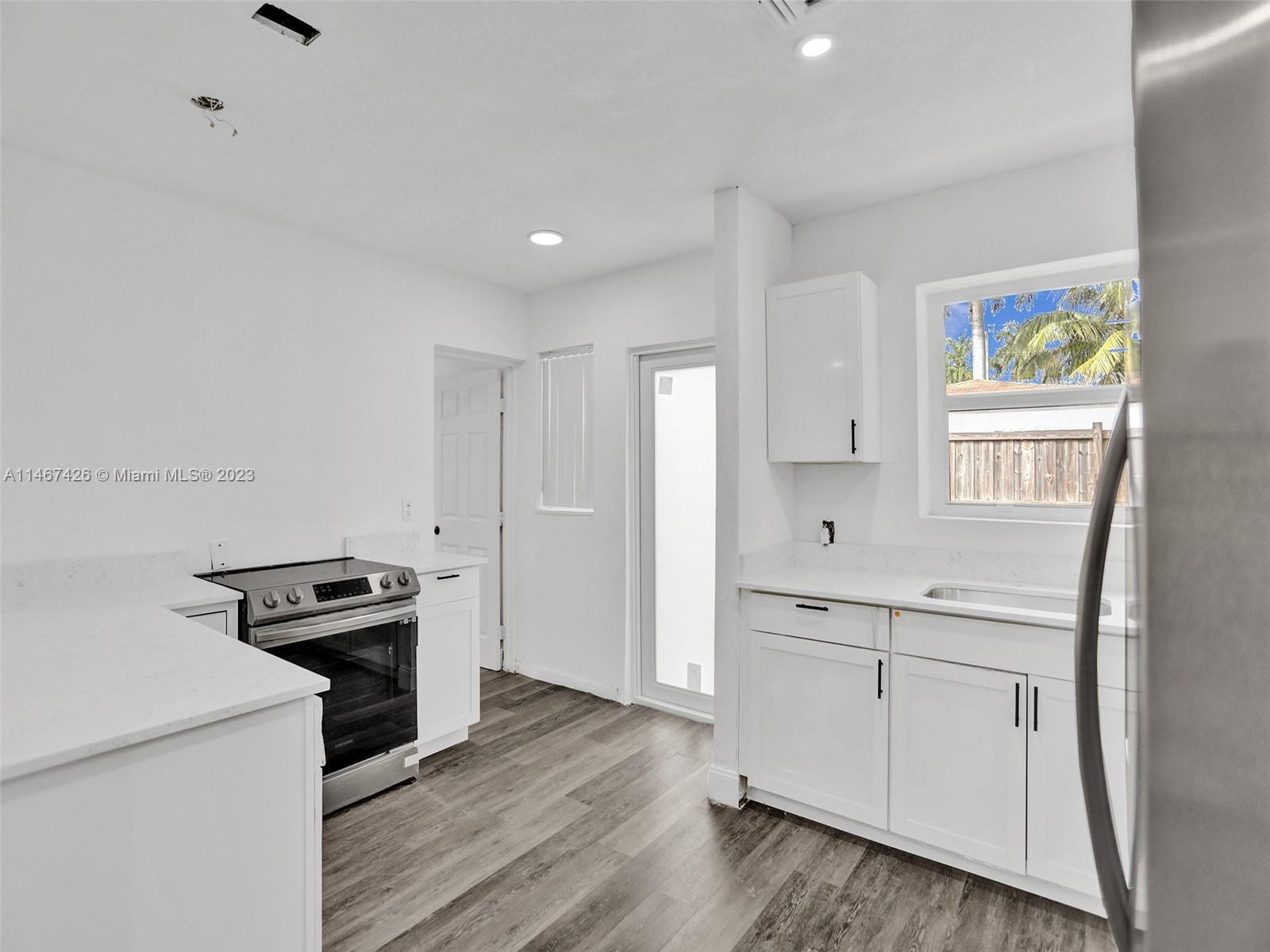 167 Northwest 84th Street Miami, FL 33150 - Photo 13 of 39 a kitchen with a refrigerator and a stove top oven