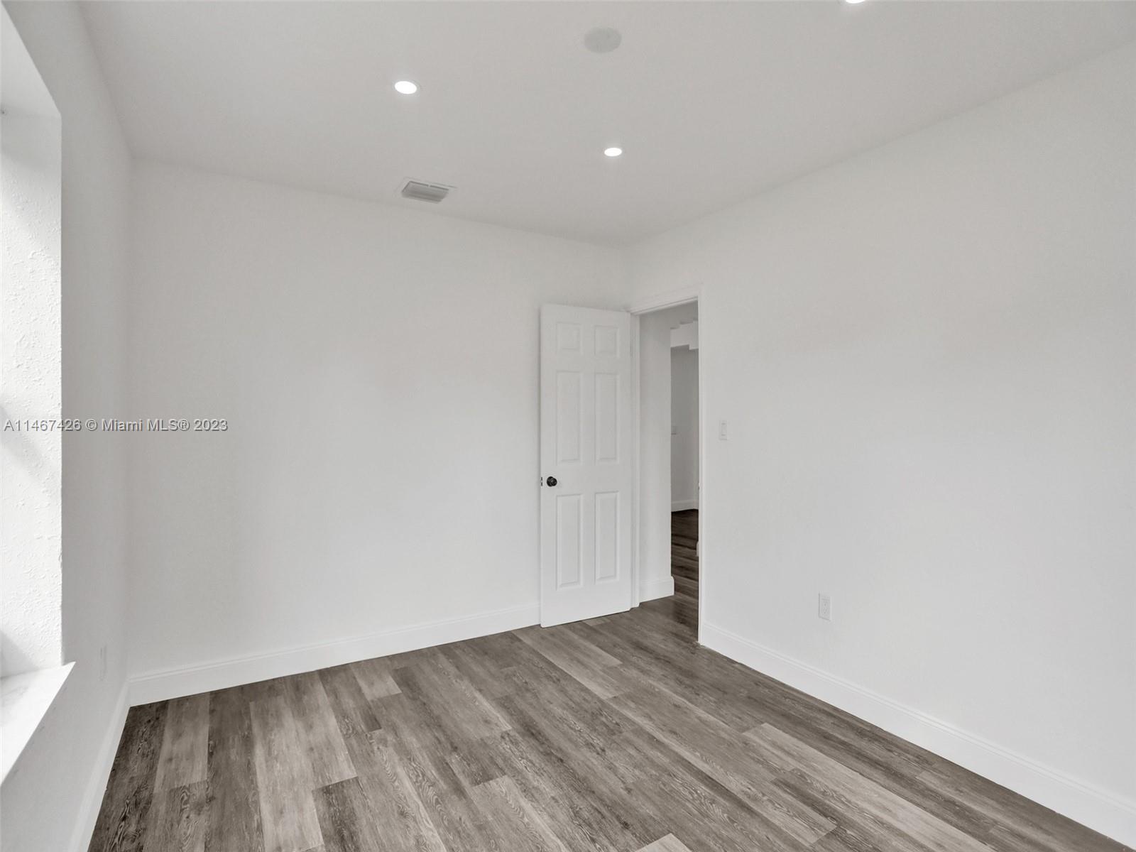167 Northwest 84th Street Miami, FL 33150 - Photo 18 of 39 a view of an empty room with wooden floor