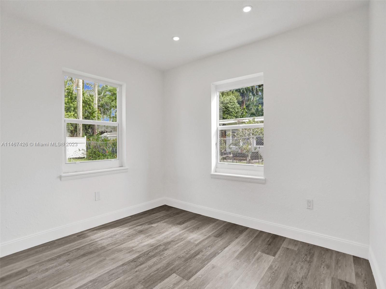 167 Northwest 84th Street Miami, FL 33150 - Photo 25 of 39 a view of an empty room with wooden floor and a window