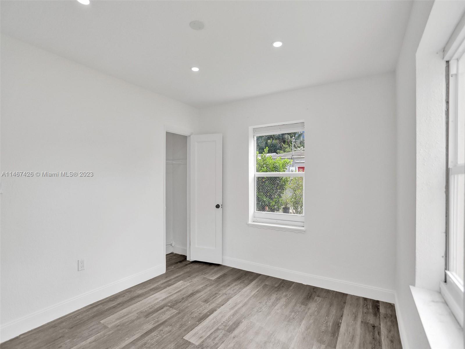 167 Northwest 84th Street Miami, FL 33150 - Photo 26 of 39 an empty room with wooden floor and windows