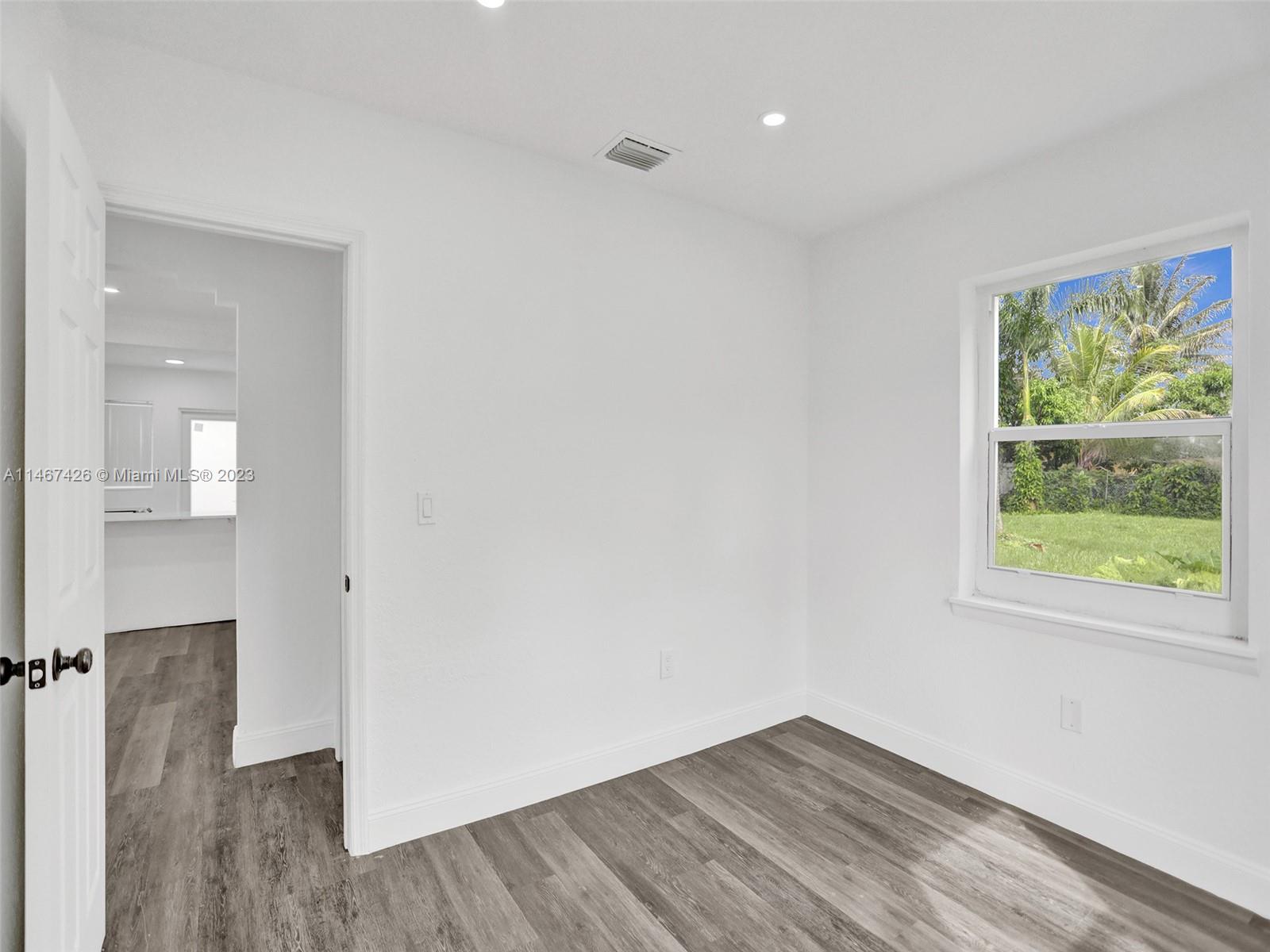 167 Northwest 84th Street Miami, FL 33150 - Photo 27 of 39 a view of an empty room with wooden floor and a window