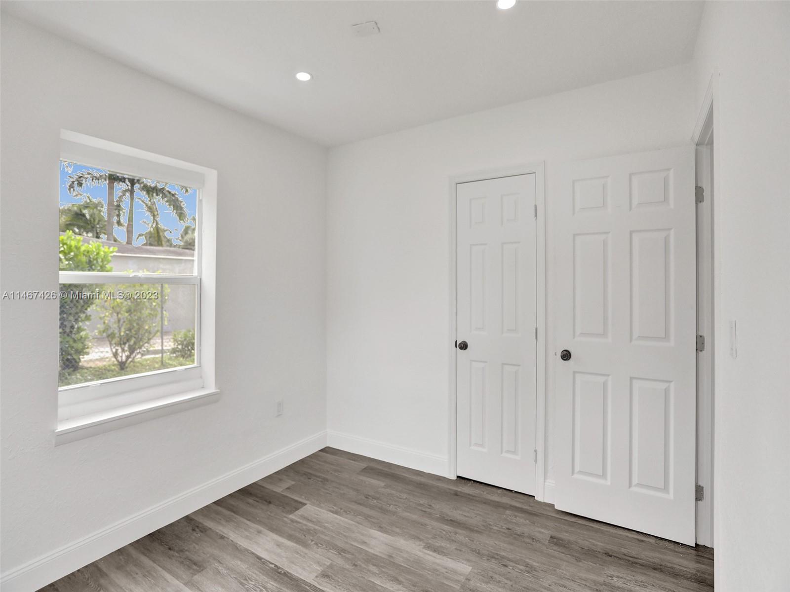 167 Northwest 84th Street Miami, FL 33150 - Photo 29 of 39 a view of an empty room with wooden floor and a window