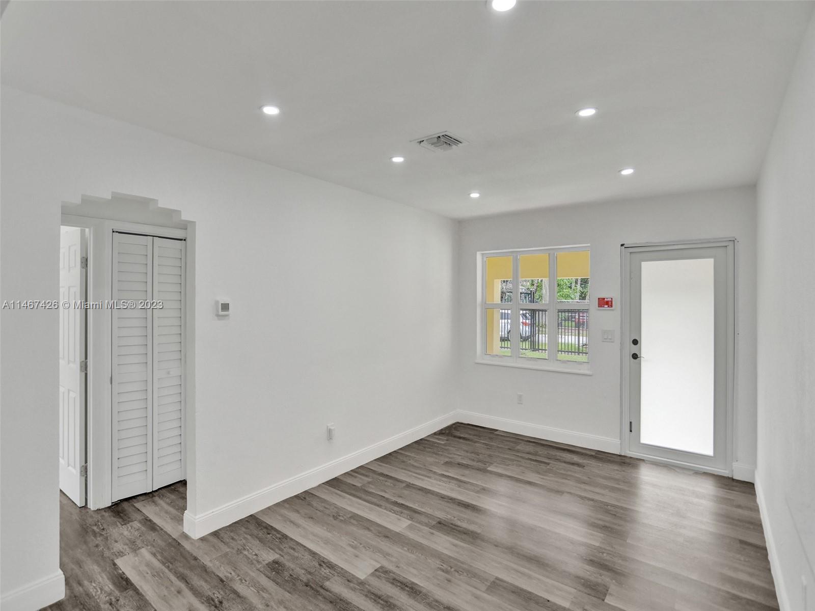 167 Northwest 84th Street Miami, FL 33150 - Photo 3 of 39 an empty room with wooden floor and windows