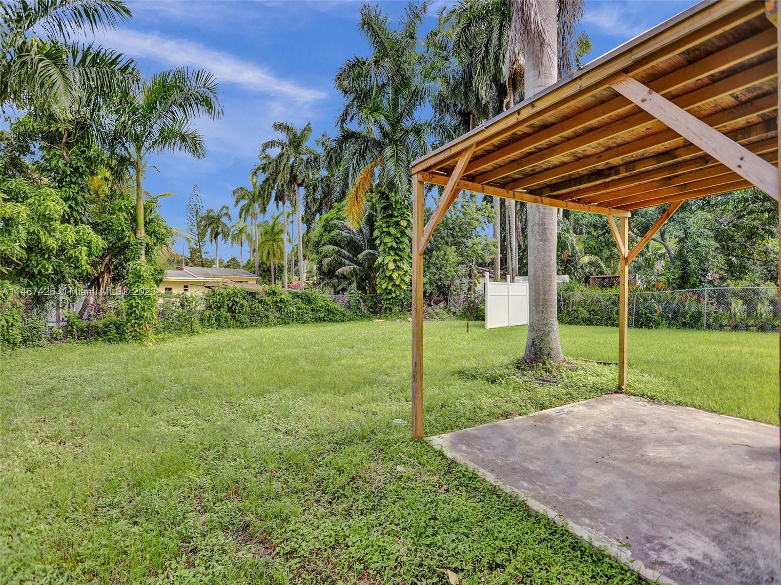167 Northwest 84th Street Miami, FL 33150 - Photo 38 of 39 a view of a backyard with table and chairs under an umbrella