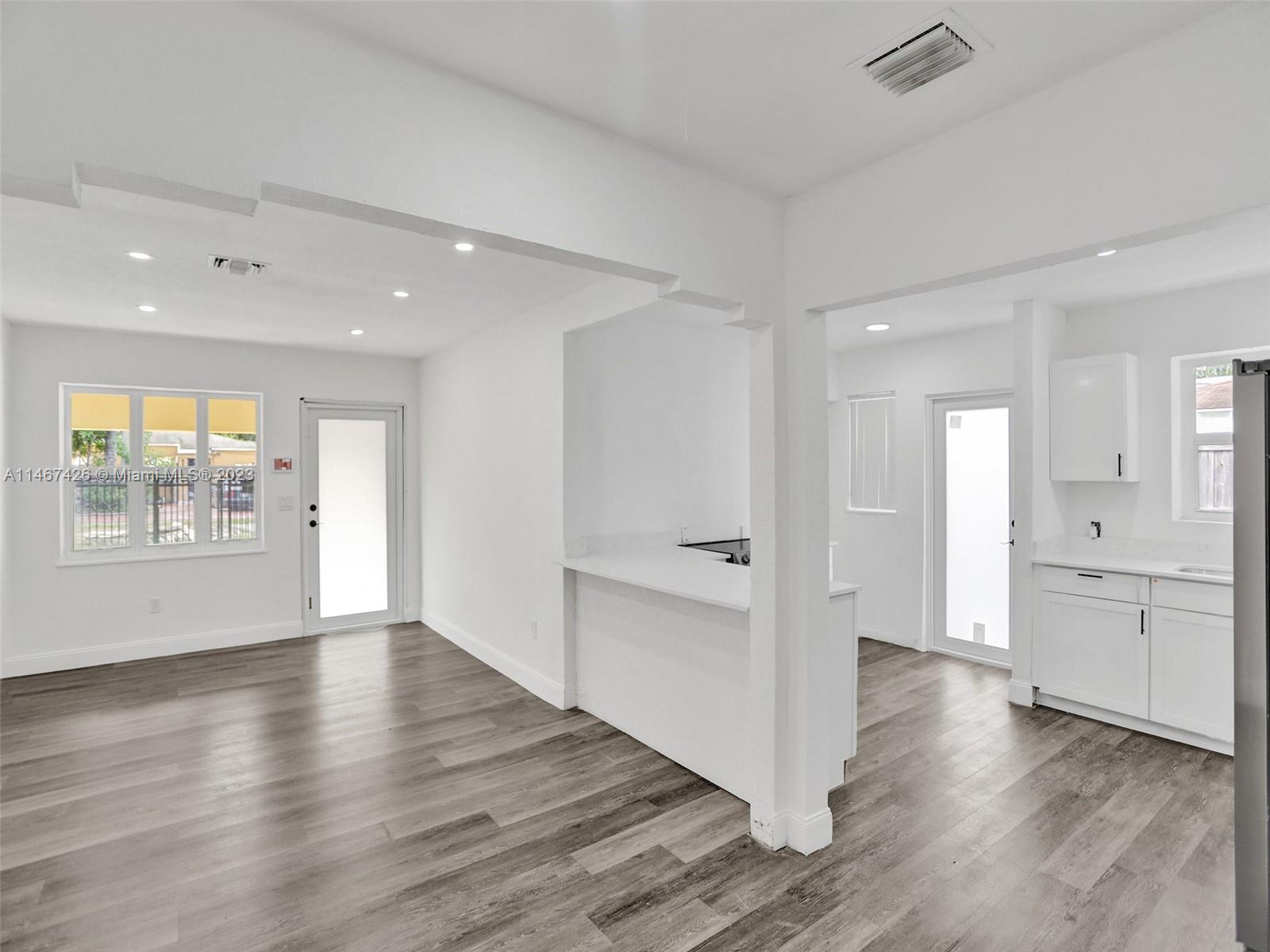 167 Northwest 84th Street Miami, FL 33150 - Photo 7 of 39 an empty room with wooden floor and windows