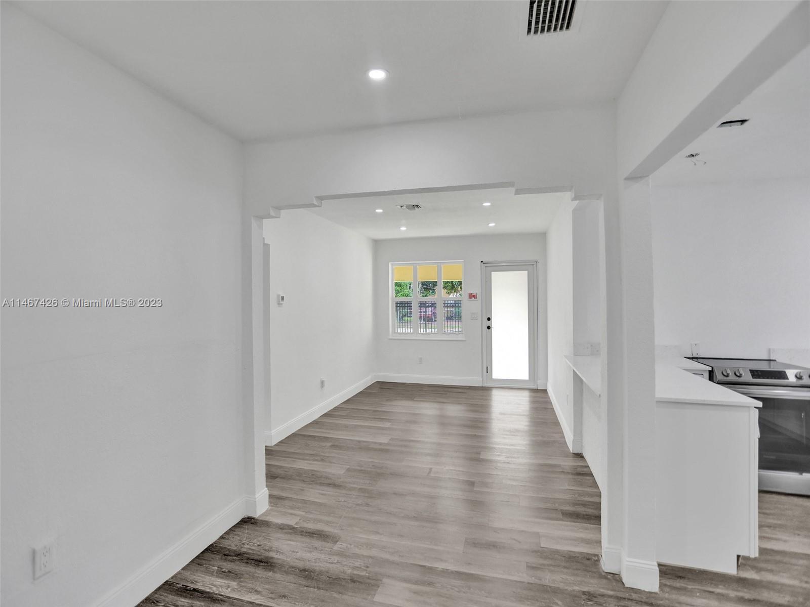 167 Northwest 84th Street Miami, FL 33150 - Photo 8 of 39 a view of an empty room with wooden floor and a window