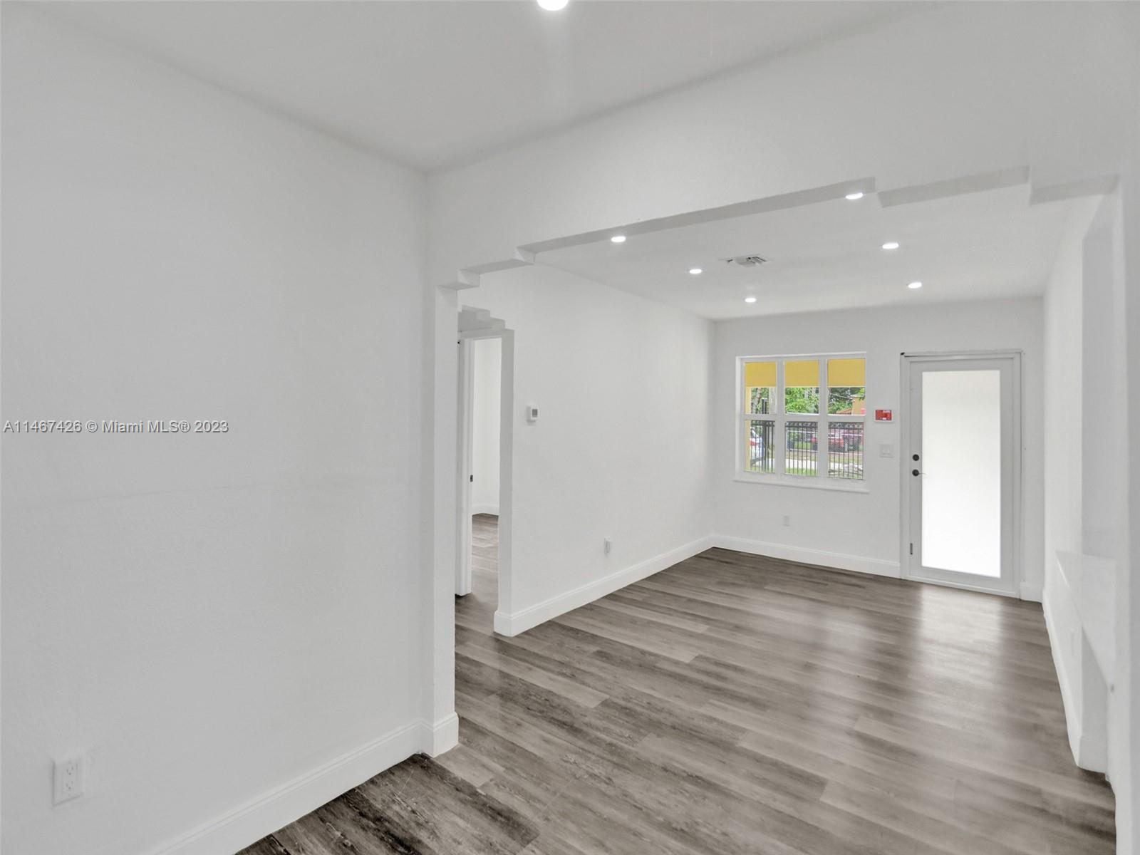 167 Northwest 84th Street Miami, FL 33150 - Photo 9 of 39 an empty room with wooden floor and windows