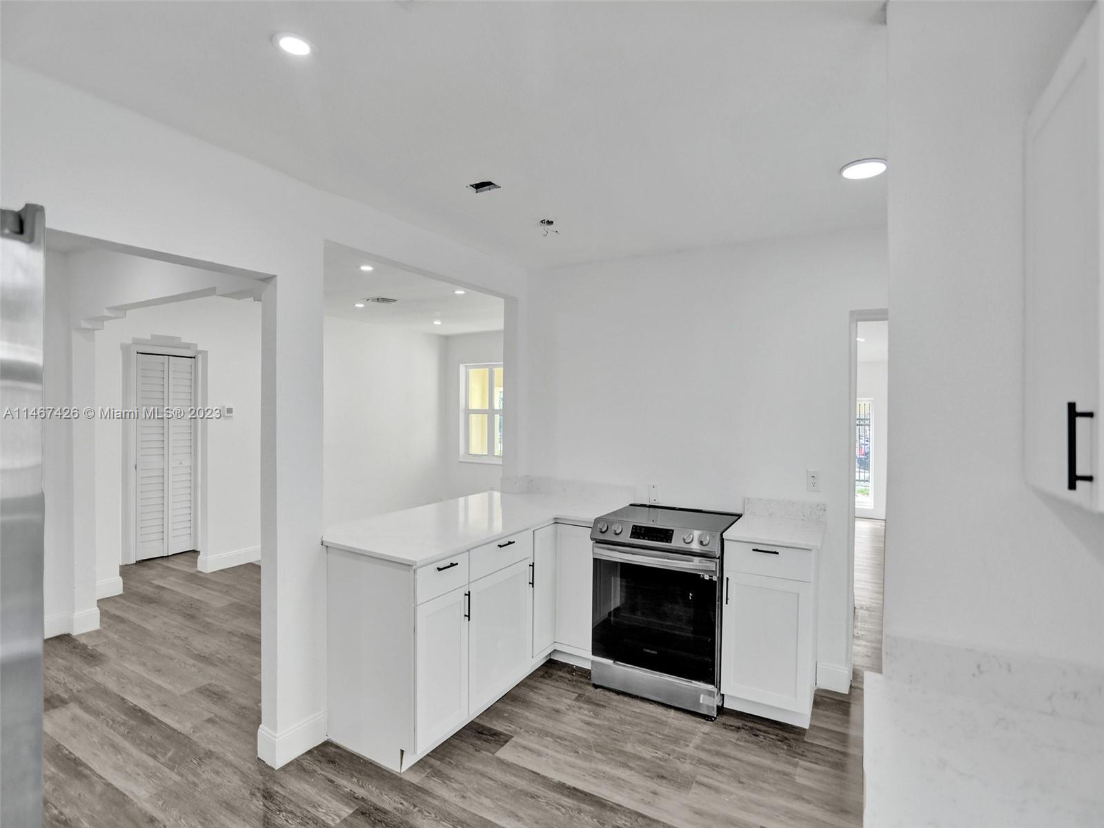 167 Northwest 84th Street Miami, FL 33150 - Photo 10 of 39 a kitchen with granite countertop a stove and a refrigerator