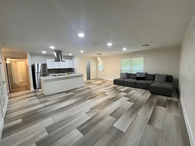 a kitchen with stainless steel appliances kitchen island granite countertop a refrigerator and a stove top oven