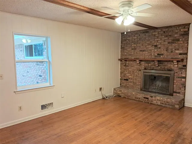 an empty room with windows and fireplace